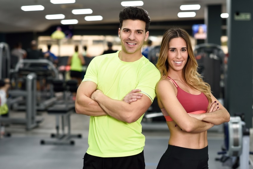 A man and woman posing at the gym